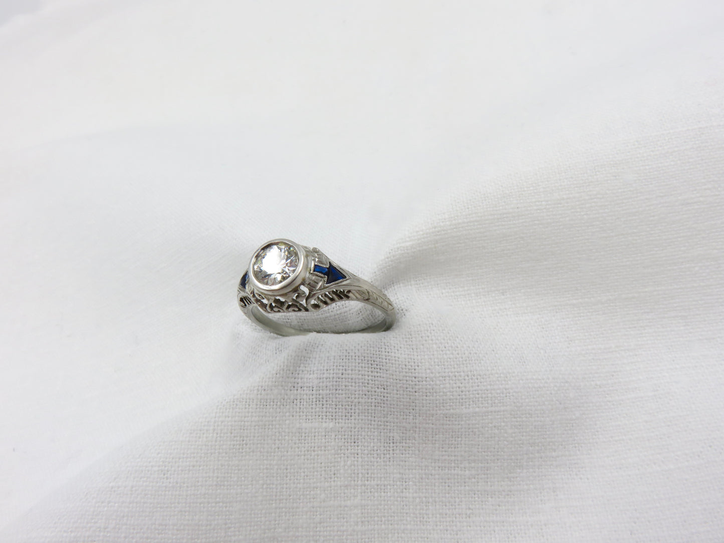 Art Deco Diamond and Platinum Engagement Ring centered with a 0.75 ct Early Modern Round Brilliant Cut Diamond. F Color