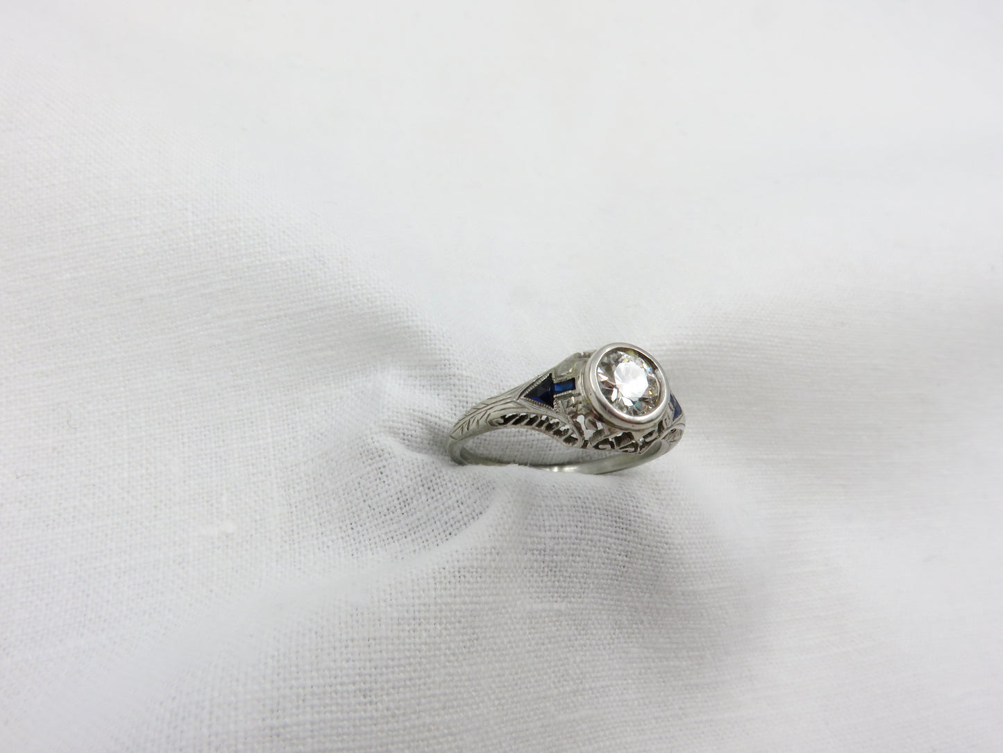 Art Deco Diamond and Platinum Engagement Ring centered with a 0.75 ct Early Modern Round Brilliant Cut Diamond. F Color