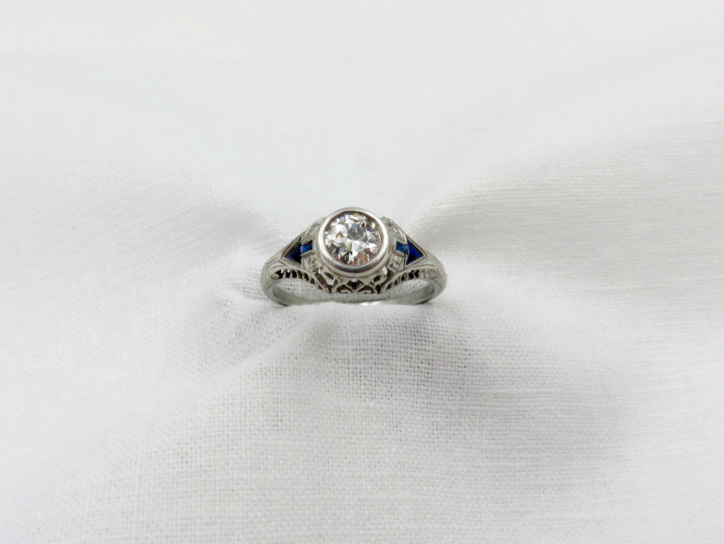 Art Deco Diamond and Platinum Engagement Ring centered with a 0.75 ct Early Modern Round Brilliant Cut Diamond. F Color