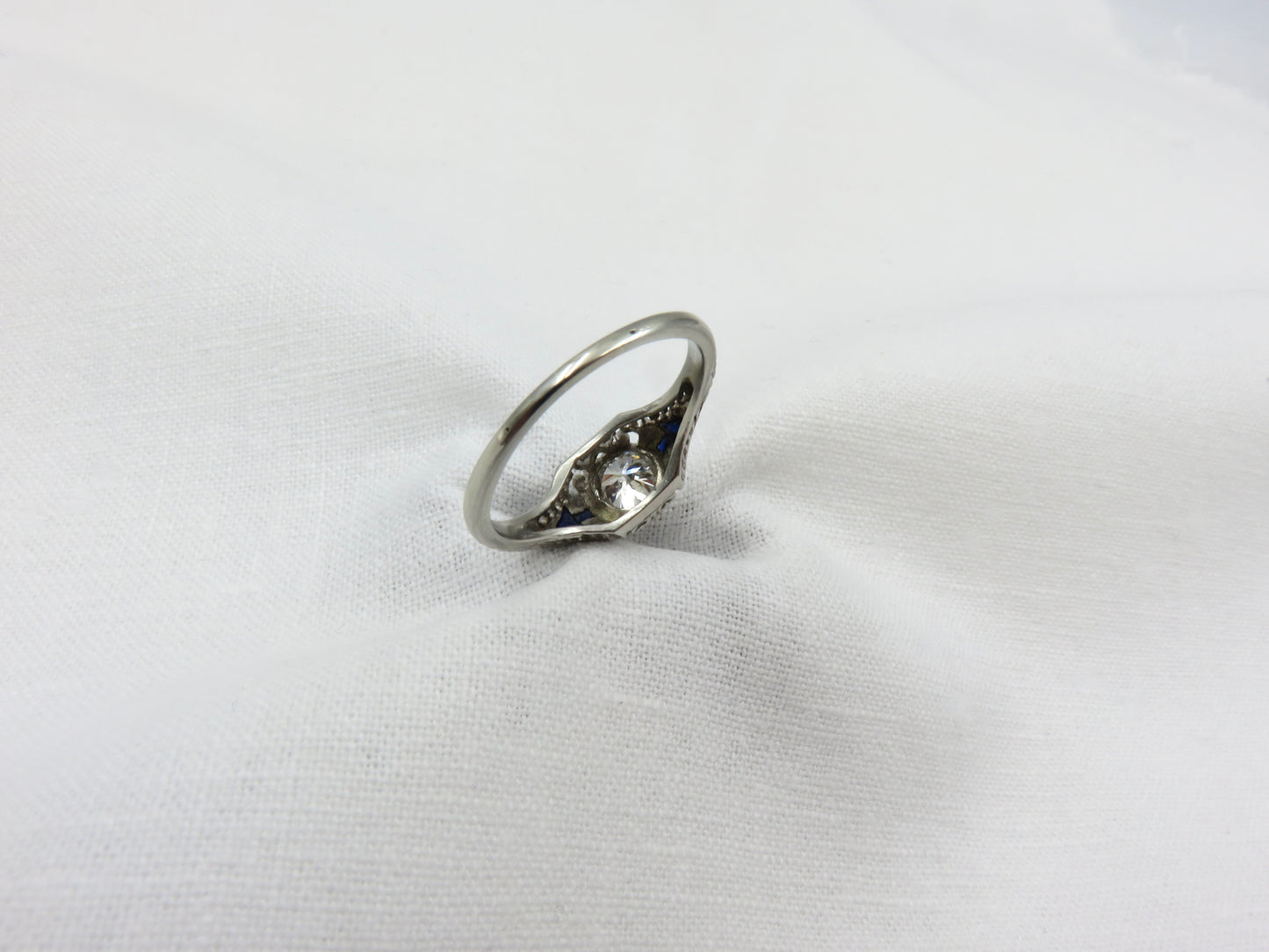 Art Deco Diamond and Platinum Engagement Ring centered with a 0.75 ct Early Modern Round Brilliant Cut Diamond. F Color