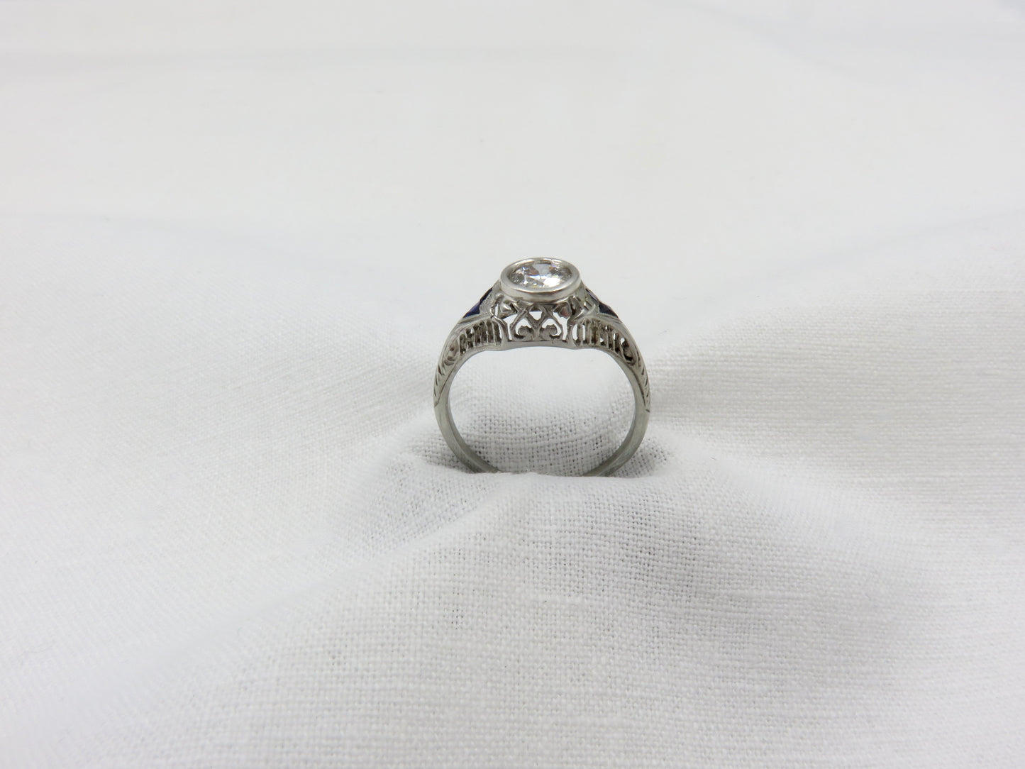 Art Deco Diamond and Platinum Engagement Ring centered with a 0.75 ct Early Modern Round Brilliant Cut Diamond. F Color